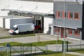 Modern logistics center, white van and trailers standingon ramp