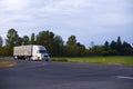 Modern long haul semi truck tarp trailer on straight highway Royalty Free Stock Photo