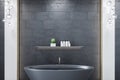 Modern luxury bathroom with black tile wall and elegant freestanding bathtub.