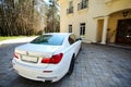 Modern luxury BMW 750Li XDrive car rear back upper view parked on stone paved parking near ancient house Royalty Free Stock Photo