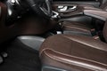 Modern luxury car brown leather interior. Part of leather car seat details with white stitching. Interior of prestige car. Comfort