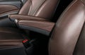 Modern luxury car brown leather interior. Part of leather car seat details with white stitching. Interior of prestige car. Comfort