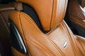 Modern Luxury car inside. Interior of prestige modern car. Comfortable leather red seats. Orange perforated leather. Modern car