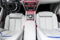 Modern Luxury car inside. Interior of a vehicle with natural wood panel. White Leather with stitching. Car detailing. Dashboard. M