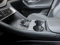 Luxury car interior showcasing a crystal gear selector, modern control panel, black leather seats, and cup holders, reflecting Royalty Free Stock Photo