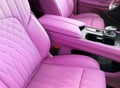 Modern luxury car pink leather interior. Part of pink leather car seat details with white stitching. Interior of prestige car. Royalty Free Stock Photo