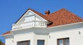 Modern luxury house with white wall, outdoor lights, balcony, rain gutter, ceramic tiles roof and attic window roller shutters Royalty Free Stock Photo