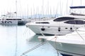 Modern luxury motor cruise yachts on the quay in the marina. Leisure activities of rich people at sea. Water transport for Royalty Free Stock Photo