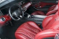 Modern luxury prestige car interior, dashboard, steering wheel. Comfortable perforated leather seats. Red perforated leather