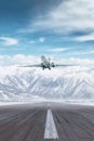 Modern luxury private jet take off airport runway at winter on the background of high scenic snow capped mountains Royalty Free Stock Photo