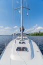 Modern luxury sailing yacht stands on the river. White hull of the yacht with close hatches. Bluer calm sea. Vertical Royalty Free Stock Photo