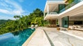 Modern luxury villa with infinity pool surrounded by tropical greenery, featuring spacious deck and elegant outdoor seating area Royalty Free Stock Photo