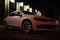 Modern luxury white sedan 2-doors sport car is parked at the night parking at the city neat the shopping center. Royalty Free Stock Photo