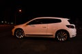 Modern luxury white sedan 2-doors sport car is parked at the night parking at the city neat the shopping center. Royalty Free Stock Photo