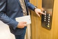 Businessman with digital tablet entering modern wooden elevator