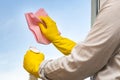 Modern man washes windows at home, elegant shirt, pink cloth, House cleaning, Concept, Equal rights and help with chores