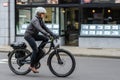 A modern man wearing white helmet rides bike in the city