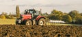 Modern massey ferguson tractor pulling a plough