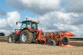 Modern massey ferguson tractor pulling a plough