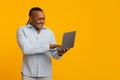 Modern mature african man surfing on internet on laptop