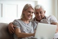 Modern mature couple using laptop relaxing at home Royalty Free Stock Photo