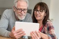 Modern mature couple using tablet