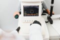 Modern medical equipment. Close up of ophthalmologist using auto refractometer while examining child eyes.