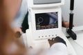 Modern medical equipment. Close up of ophthalmologist using auto refractometer while examining child eyes.