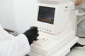 Modern medical equipment. Close up of ophthalmologist using auto refractometer while examining child eyes. Royalty Free Stock Photo