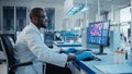 Modern Medical Laboratory: Male Scientist, Typing on Keyboard working on Computer, Scren Shows DNA