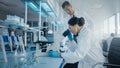 Modern Medical Research Laboratory: Portrait of Two Scientists Working, Using Microscope, Analyzin Royalty Free Stock Photo