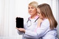 Modern medicine. Doctor showing test results on black mock up digital tablet screen. Two doctors using tablet in meeting at the