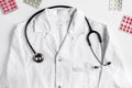 Modern medicine workplace with overall and stethoscope white table flat lay space for text Royalty Free Stock Photo