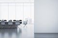 Modern meeting room interior with mock up banner on wall, reflections on concrete flooring and panoramic window with city view and Royalty Free Stock Photo