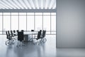 Modern meeting room interior with mock up place on wall, concrete flooring and panoramic window with city view and daylight. Royalty Free Stock Photo