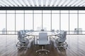 Modern meeting room interior with reflections on wooden parquet flooring and panoramic window with city view and daylight. Royalty Free Stock Photo