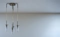 Modern metal and glass lamp with four lights hanging form the ceiling, empty space right side