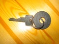 A modern metal key with a metal ring for inscription, lies on a wooden surface Royalty Free Stock Photo