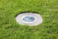 Modern metal spotlight led lamp for outdoor use of circular shape recessed in a grass area