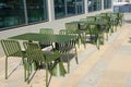 Modern metal tables and chairs are khaki color. Empty outdoor cafÃ©. Urban street furniture