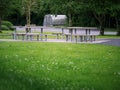 Modern metal tables in a park, Picnic lunch area. Nobody, Green grass and trees Royalty Free Stock Photo