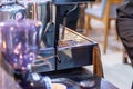 Modern metallic stainless steel coffee maker or espresso machine at the cafe kitchen with warm and cozy light coffee shop
