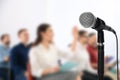 Modern microphone and people at business training, closeup