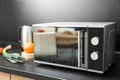 Modern microwave oven and ingredients on table Royalty Free Stock Photo