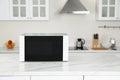 Modern microwave oven on white table in kitchen, space for text Royalty Free Stock Photo