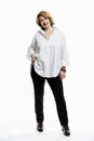 A modern middle-aged woman with red hair in a white shirt and black trousers. Happiness and positivity. White background. Vertical