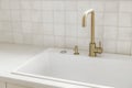 Modern minimal kitchen design. Stylish brass faucet and white granite sink on counter at window in new scandinavian house. Modern