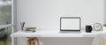 Modern minimal white office desk workspace with laptop mockup and copy space over white wall Royalty Free Stock Photo