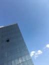 Modern minimalist architecture. Tall office building glass windows against clear blue sky business texture background Royalty Free Stock Photo