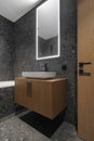 Modern minimalist bathroom dark interior design with dark stone tiles and wood furniture Royalty Free Stock Photo